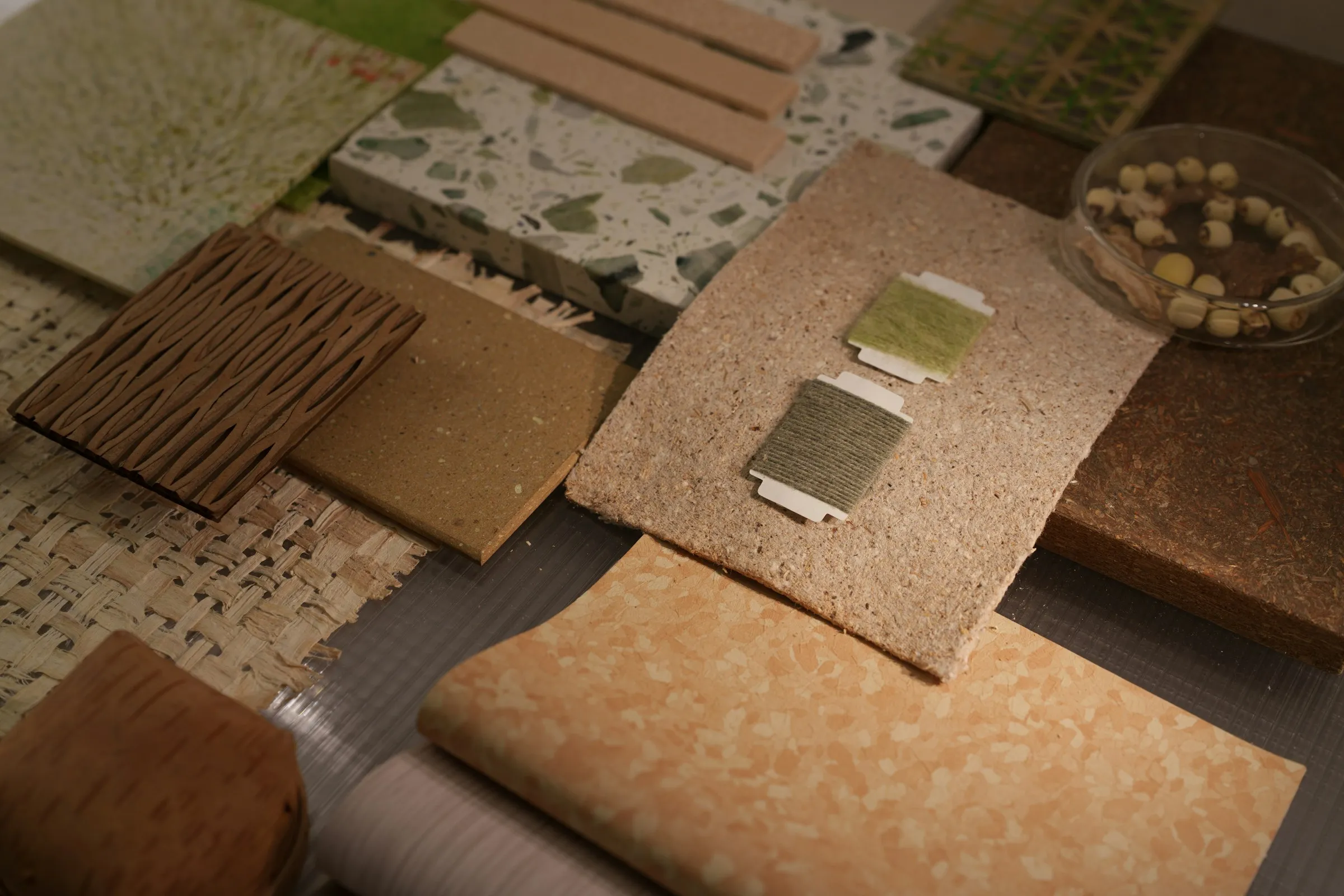 Curated set of flooring samples laid out on a workspace surface in cream, charcoal, and cool-blue tones.